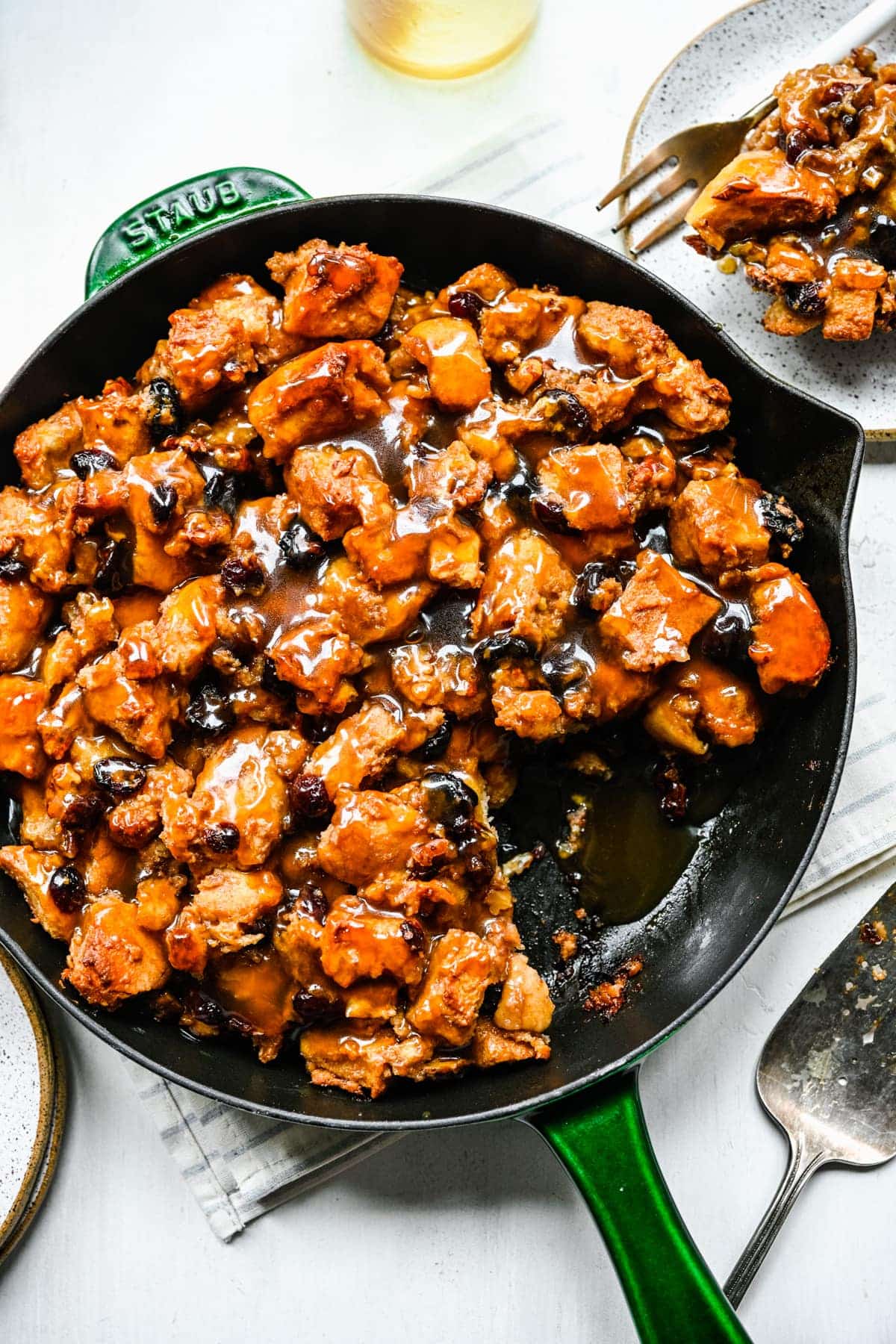 A vegan skillet filled with holiday recipes and a fork on a table.