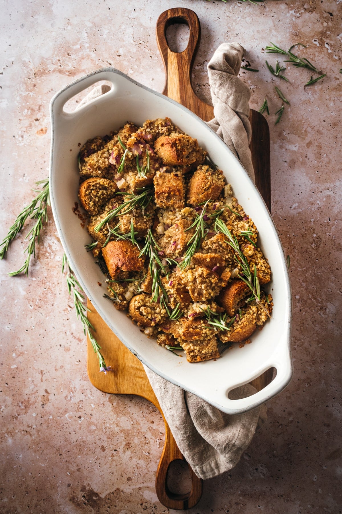 Vegan stuffing in a white platter on a wood cutting board.