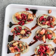 Cherry bruschetta with a balsamic glaze on a white enamel tray