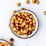Bowl of cheesy roasted chickpeas on a gray background.