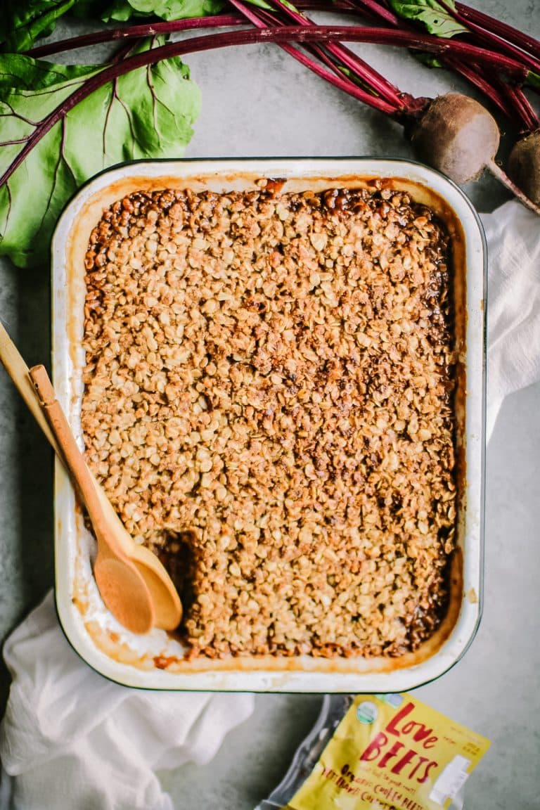Straight down shot of apple crisp with wooden spoons and fresh beets.