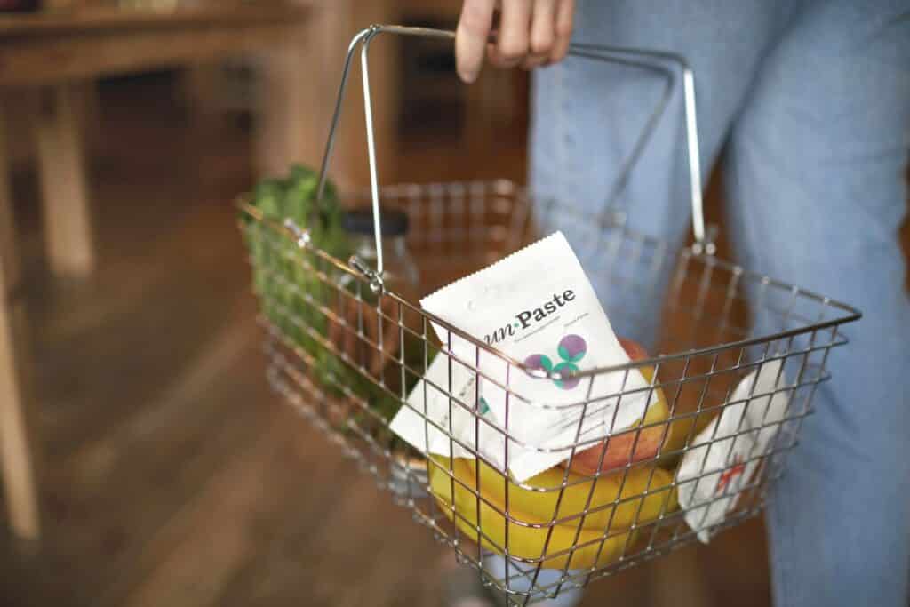 White bag of toothpaste bits in a metal shopping basket.