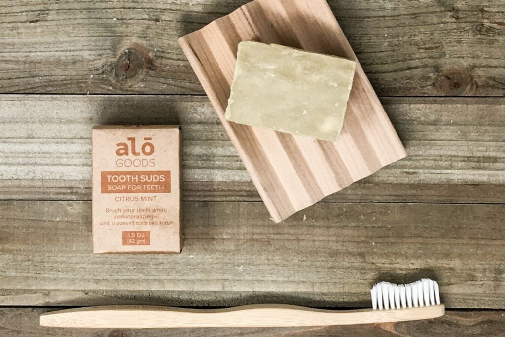 Bar of toothpaste soap on a wooden soap holder.