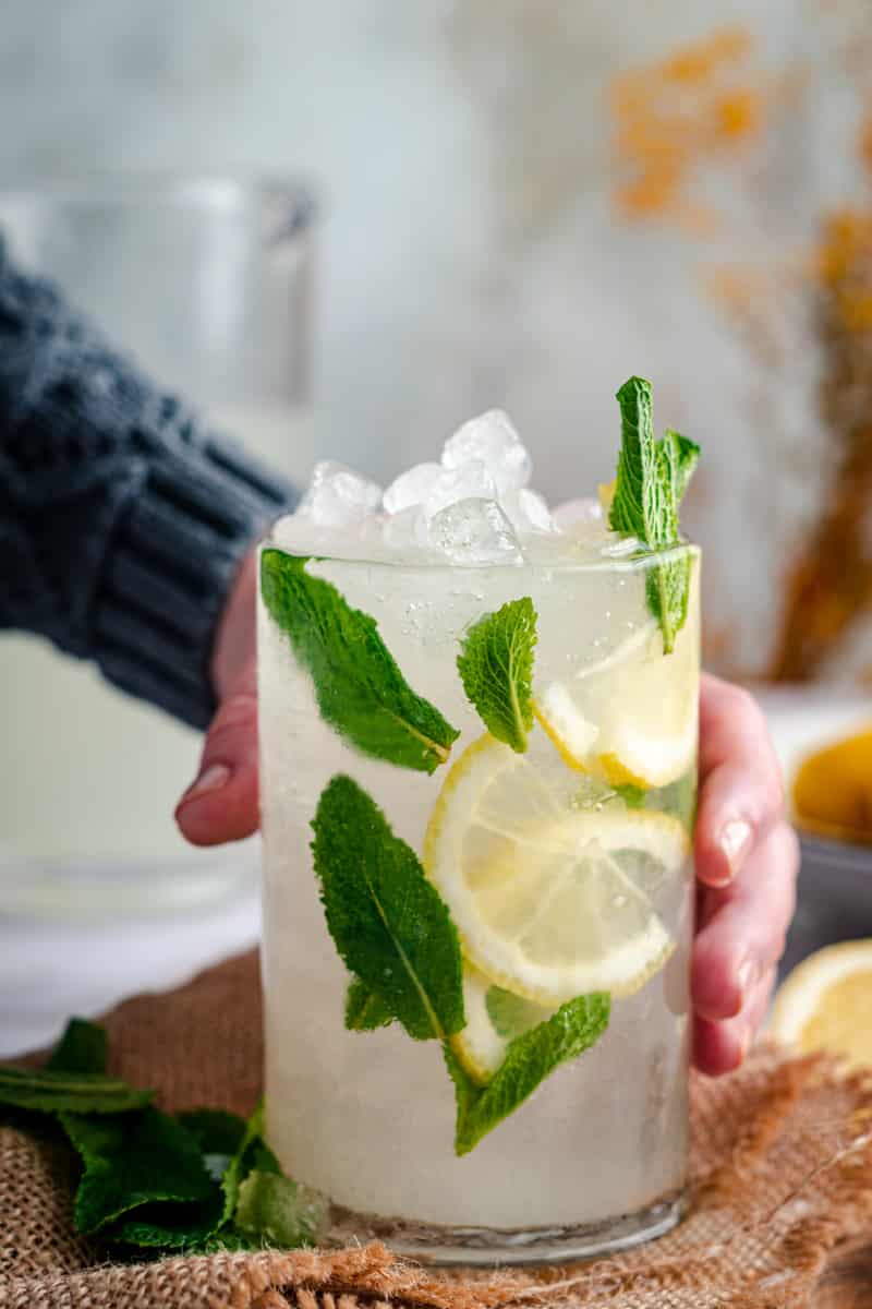 Woman grabbing a fresh glass of lemonade.