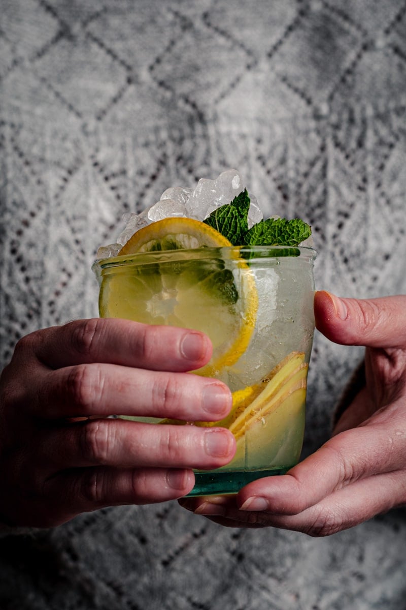Woman holding a cup of ginger lemonade.