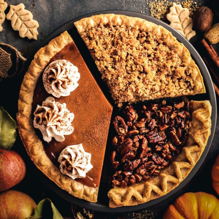 A pie with three slices: one boasts whipped cream, one crumbled topping, and another pecans.