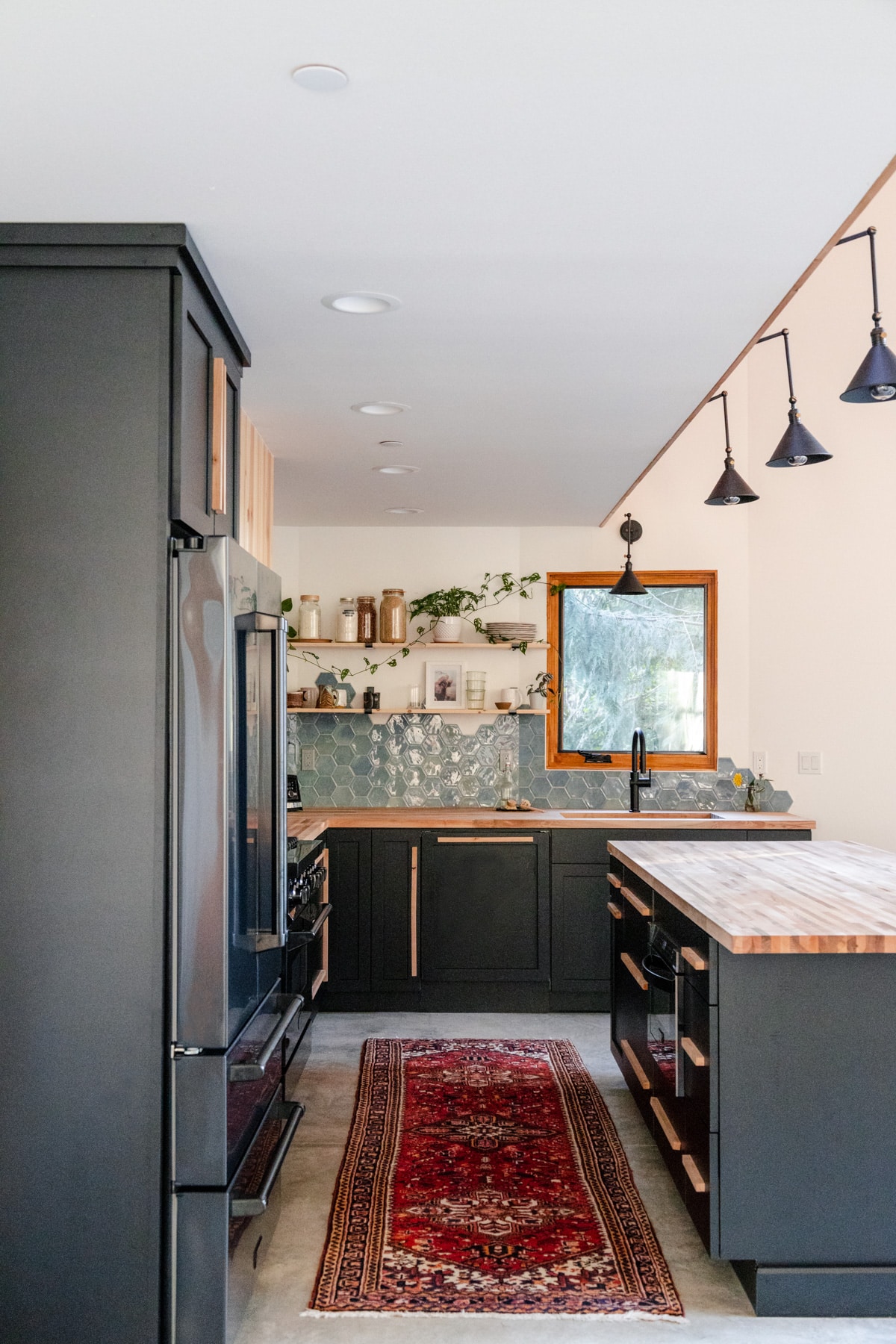 Panel ready ZLINE dishwasher inset into black cabinets with a wood drawer pull.