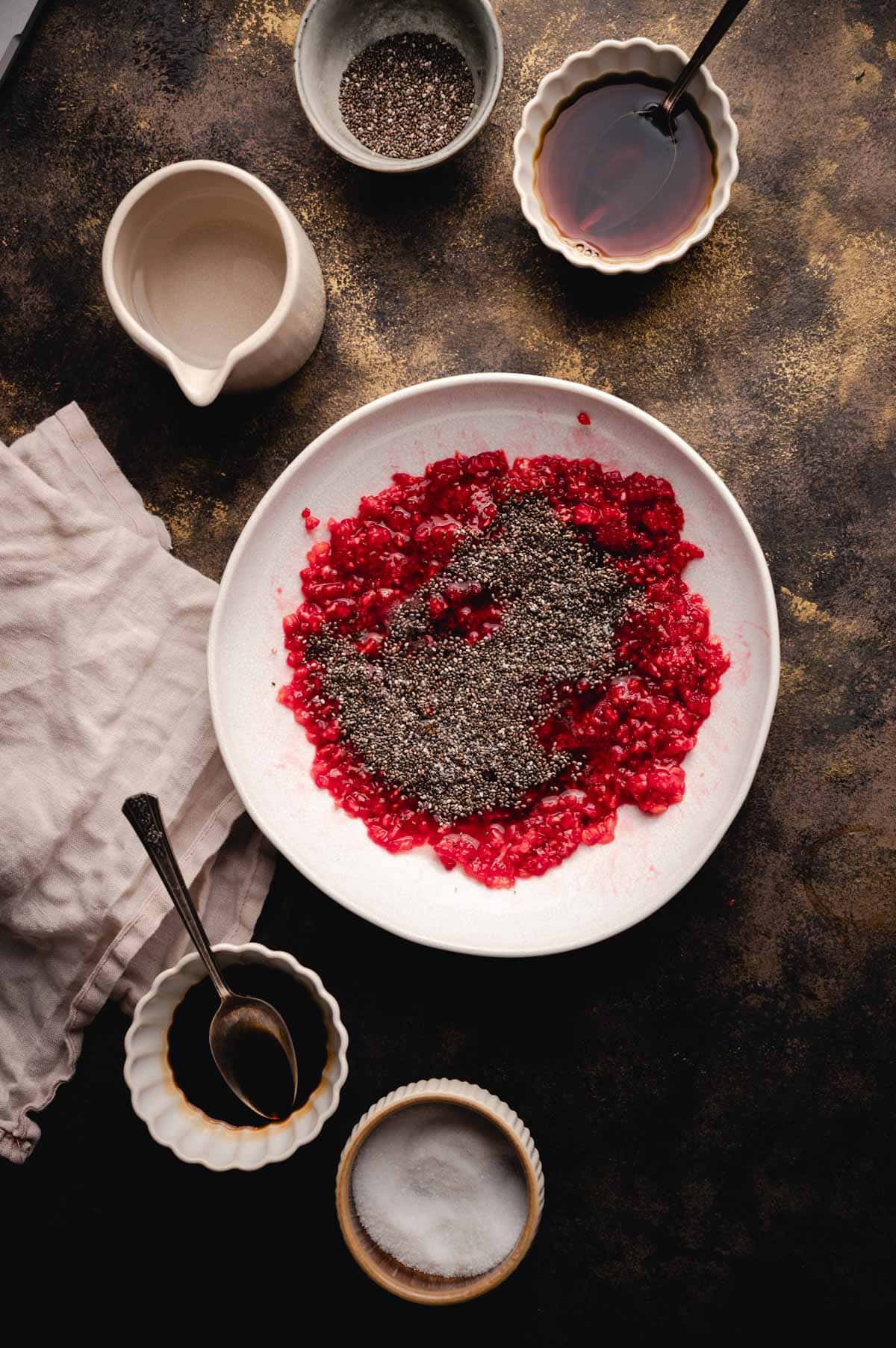 Mashed raspberries with chia seeds, maple syrup, and water added in.