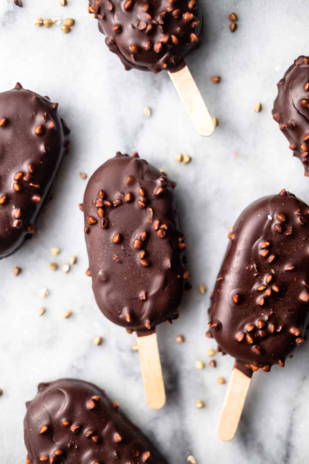 Several chocolate crunk coated vegan ice cream bars.