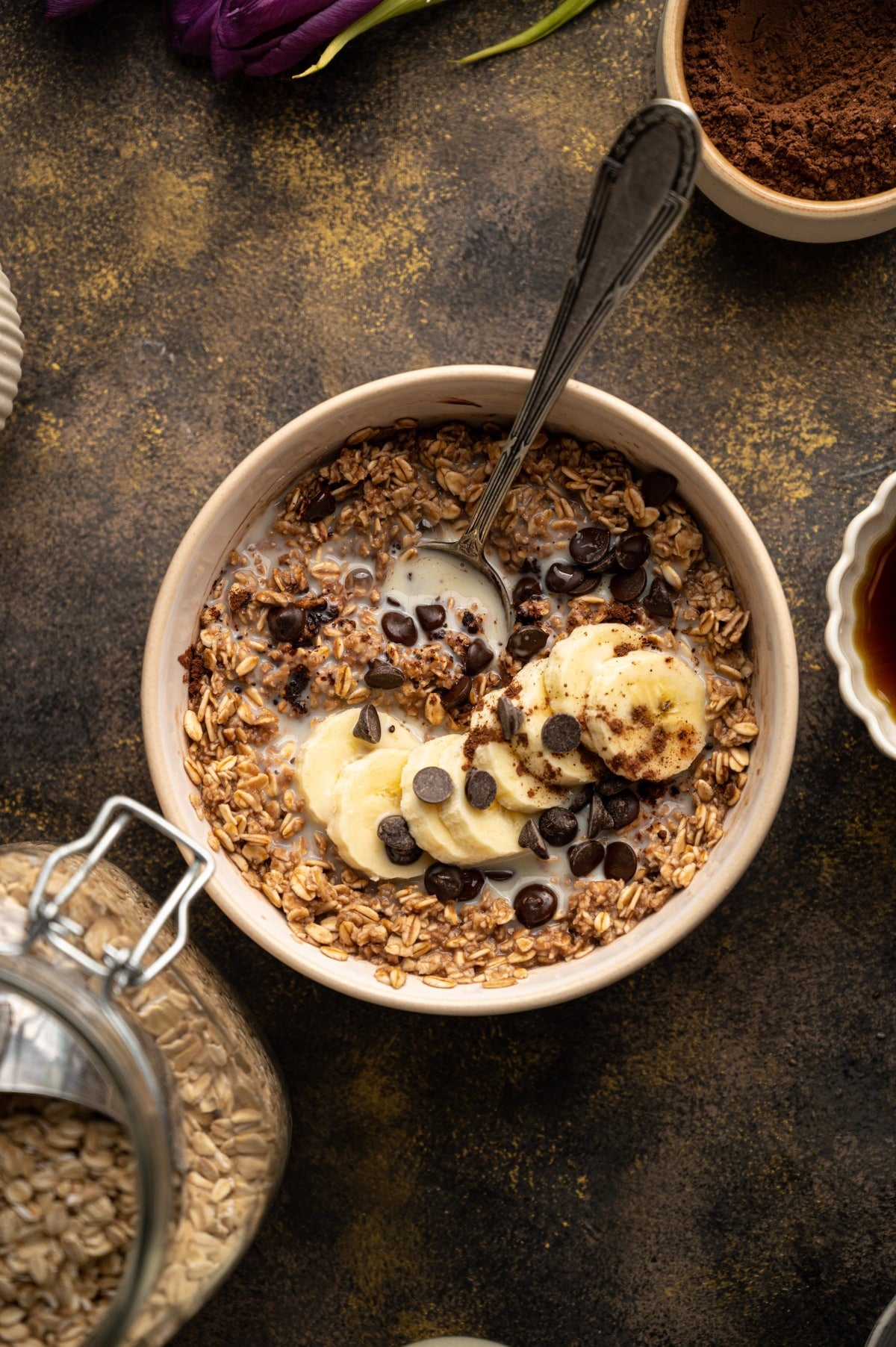 Close up of chocolate oatmeal with a spoon coming out of the bowl.