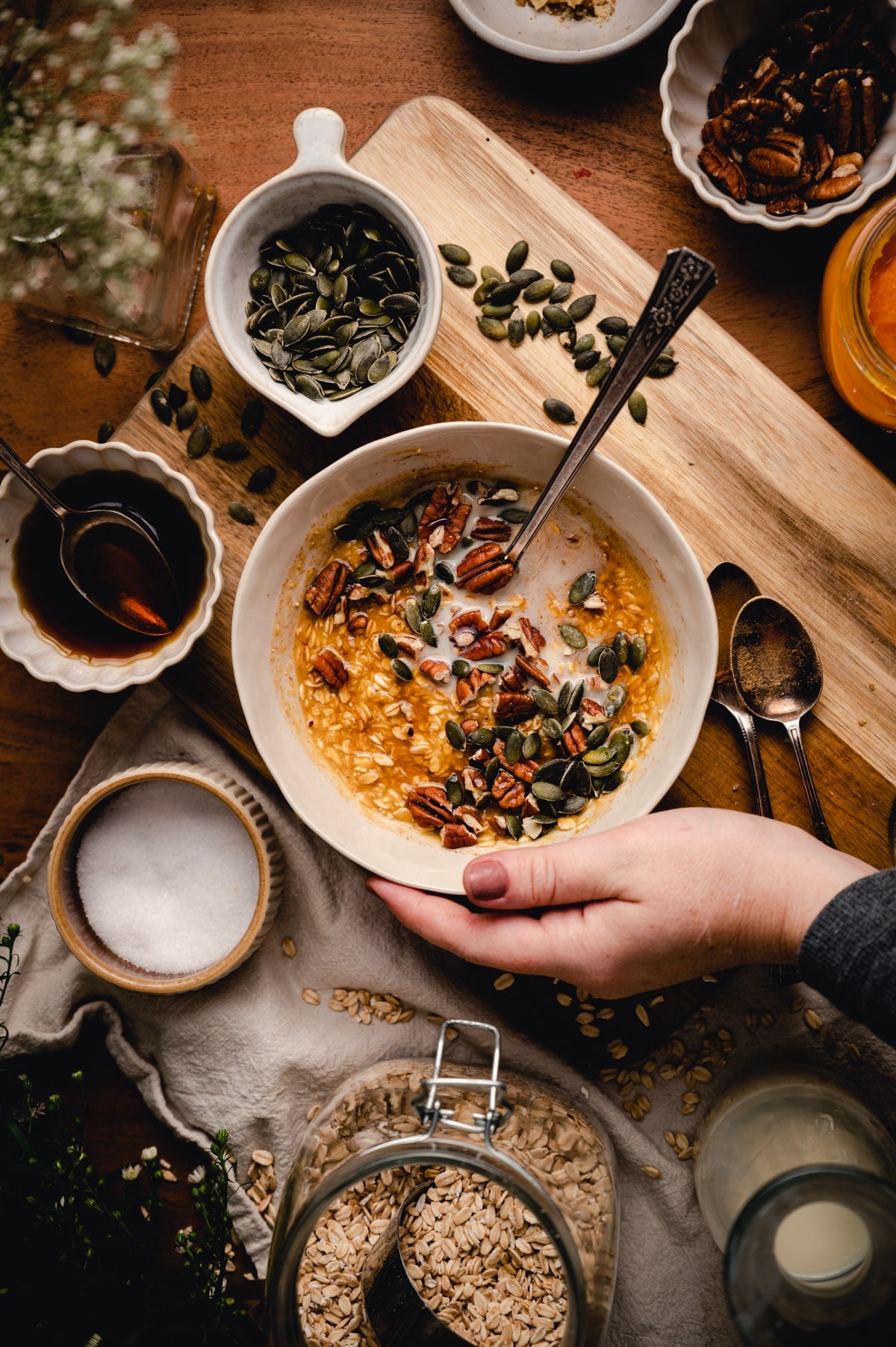Woman grabbing bowl of pumpkin oatmeal.