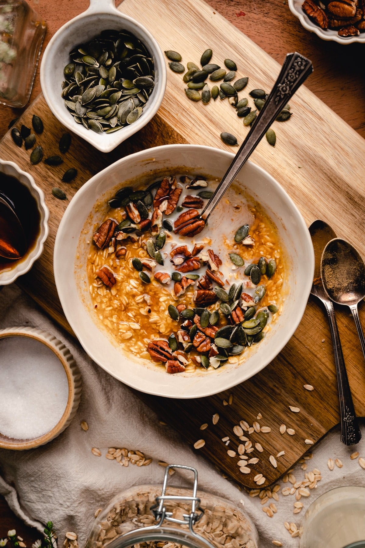 Orange colored pumpkin oatmeal topped with pecans and pepitas.