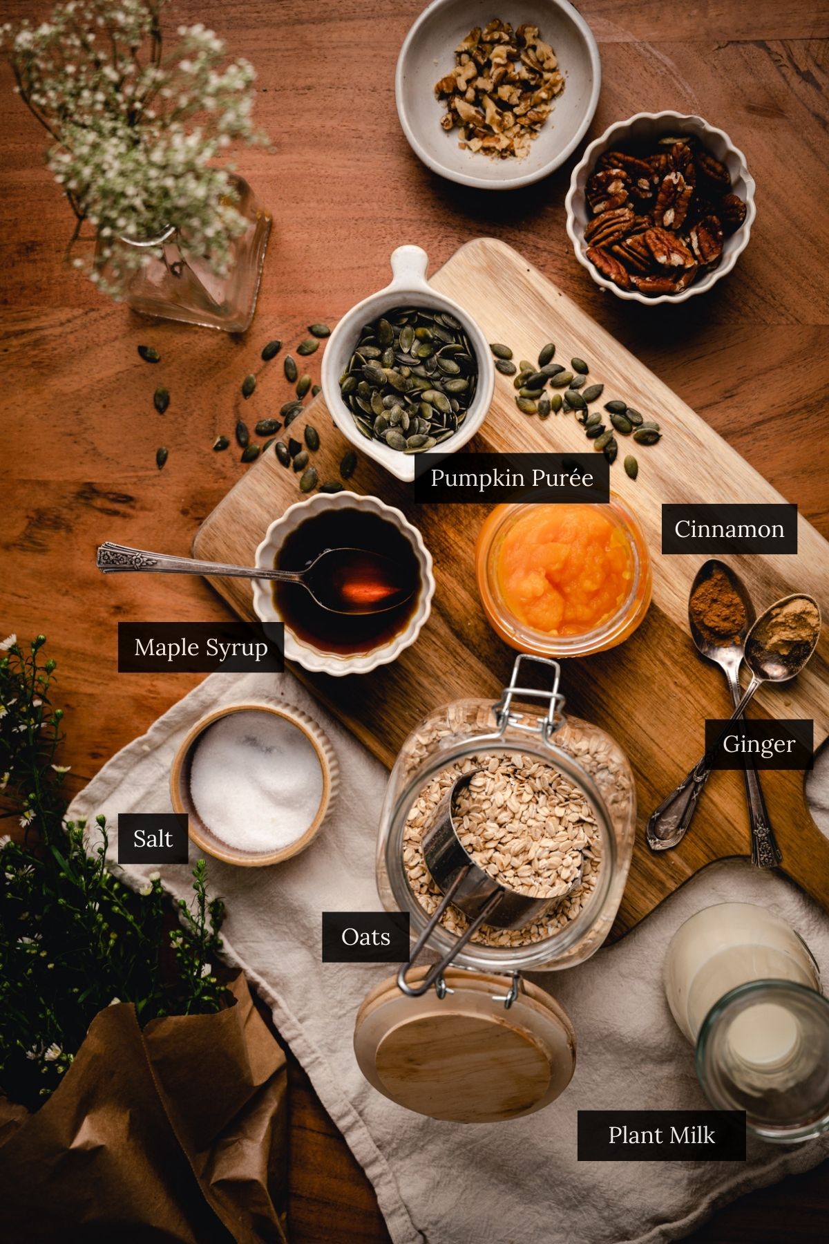 Ingredients for a cozy pumpkin oatmeal: oats, pumpkin purée, plant milk, maple syrup, cinnamon, ginger, and a pinch of salt all labeled.