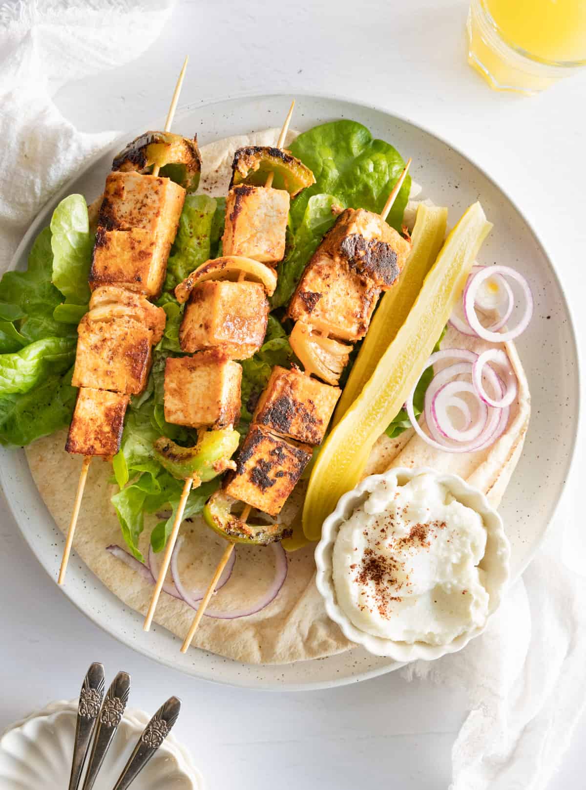 Grilled vegan tofu skewers served on a plate.