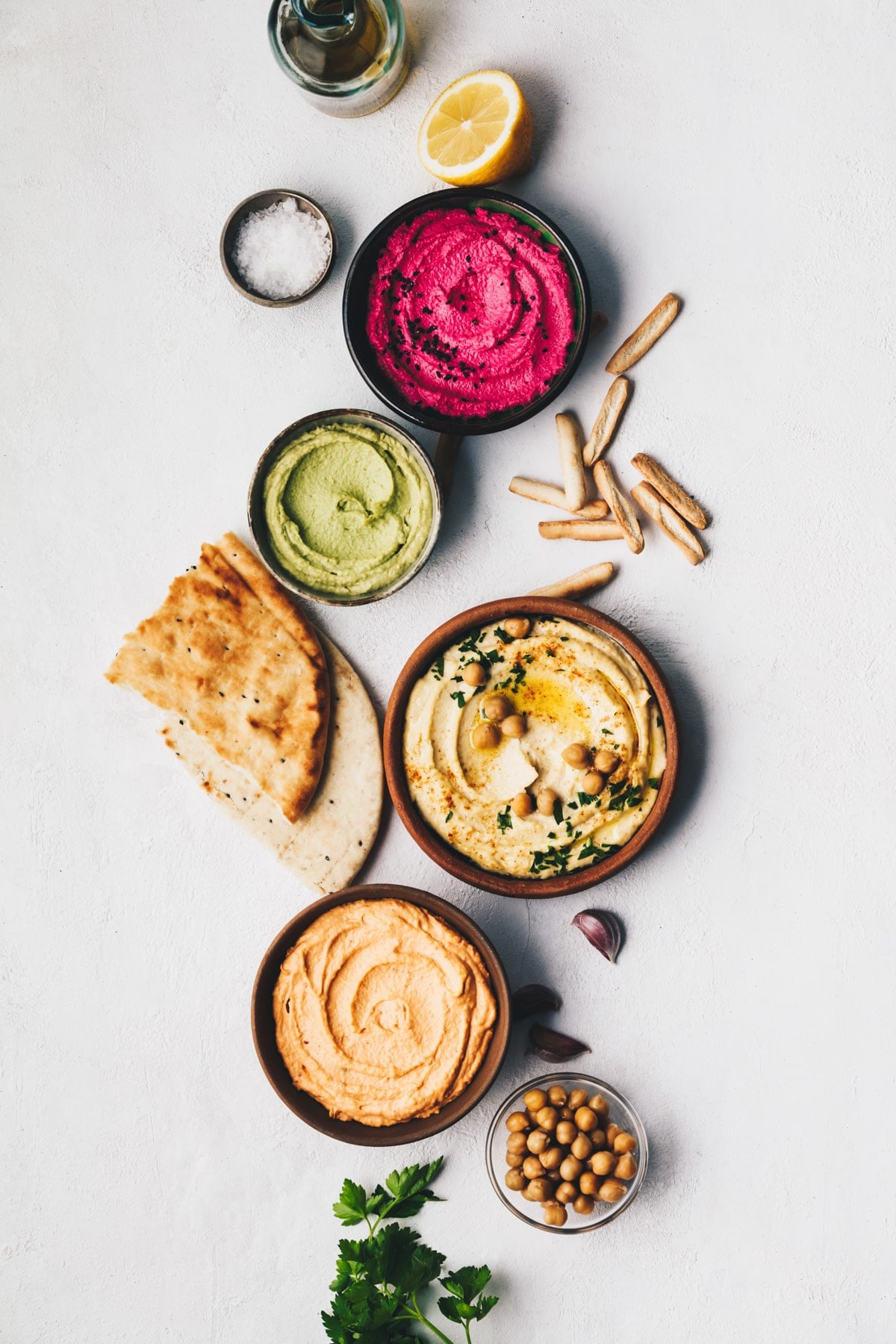 Chickpea hummus, herbs hummus, beetroot hummus and lentils humus with bread sticks and fresh bread.