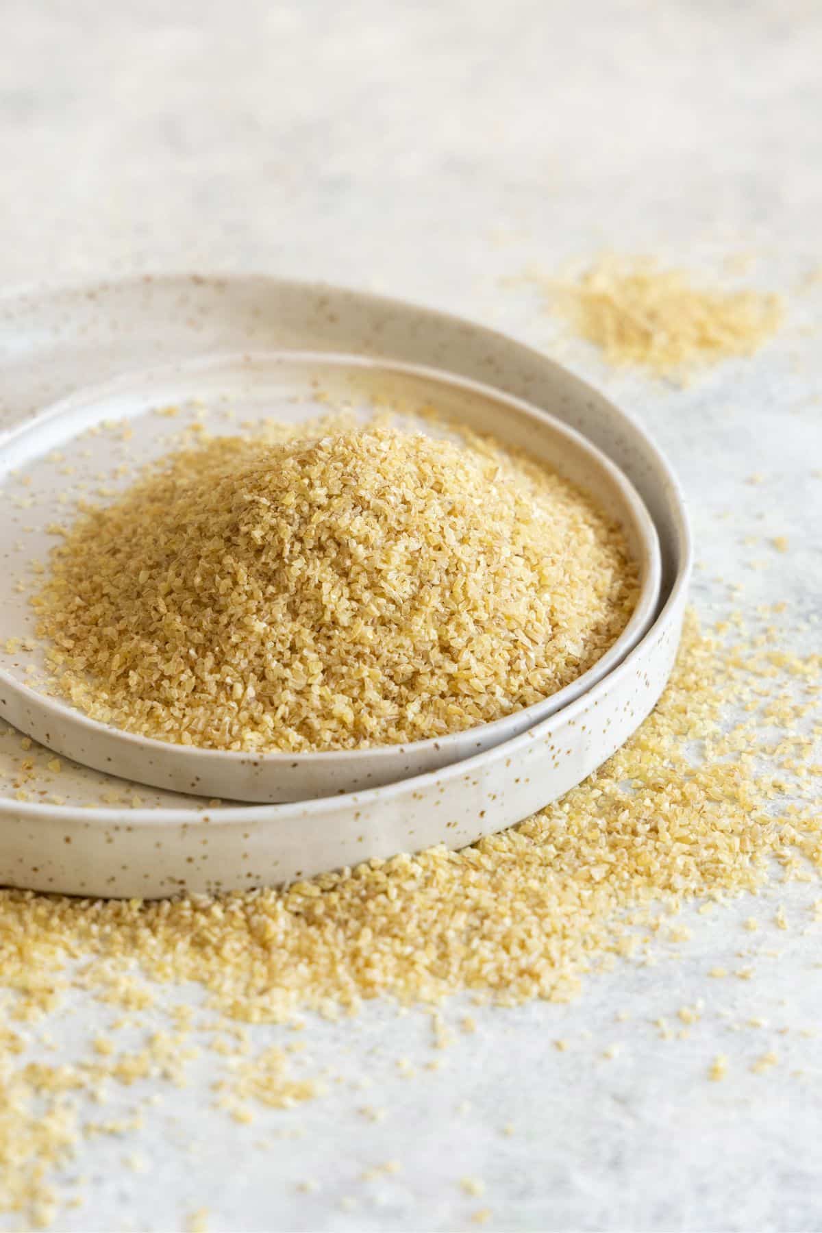 Yellow-white bulgur on handmade white ceramic plates.