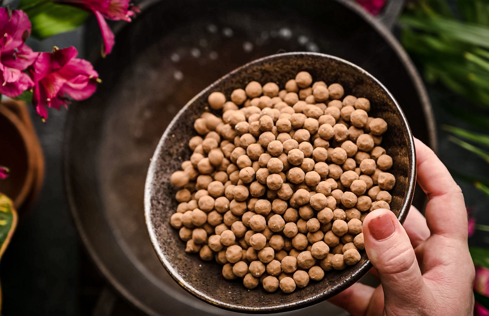 Bowl of tapioca pearls being poured into a pot of boiling water.