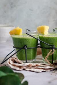 Vibrant green smoothie sitting on cloth napkin.