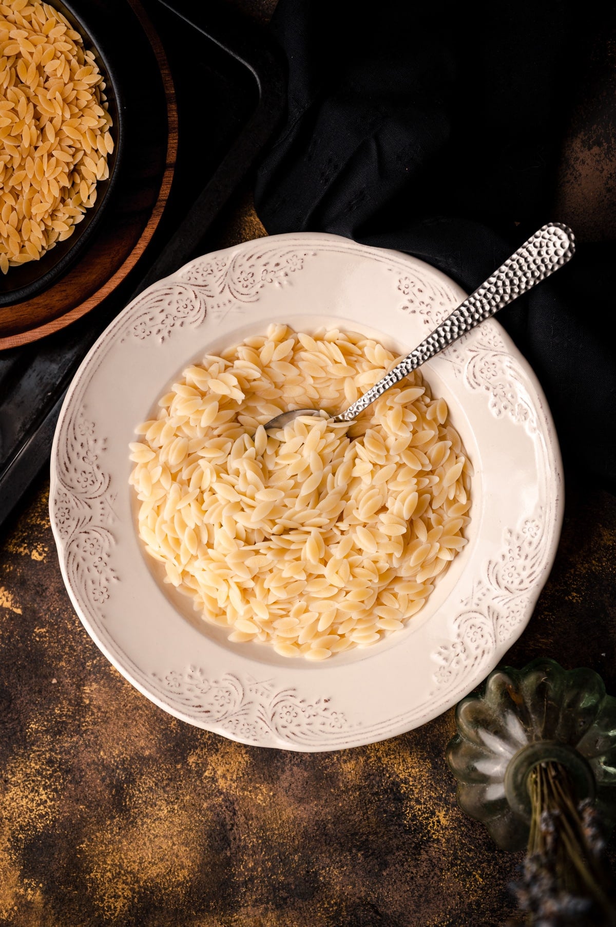 Close up of cooked orzo in a white bowl.