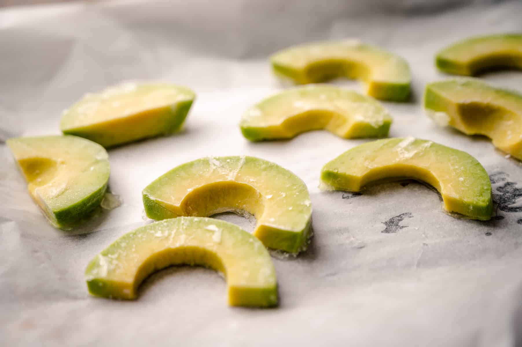 Avocado slices frozen with ice crystals on them.