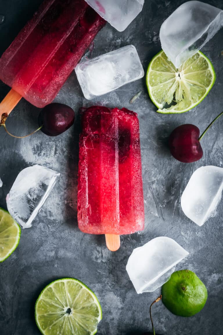 Popsicles with cherry, lime and ice cubes.
