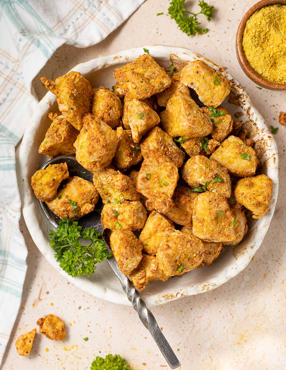 Chicken nuggets in a white bowl with parsley.