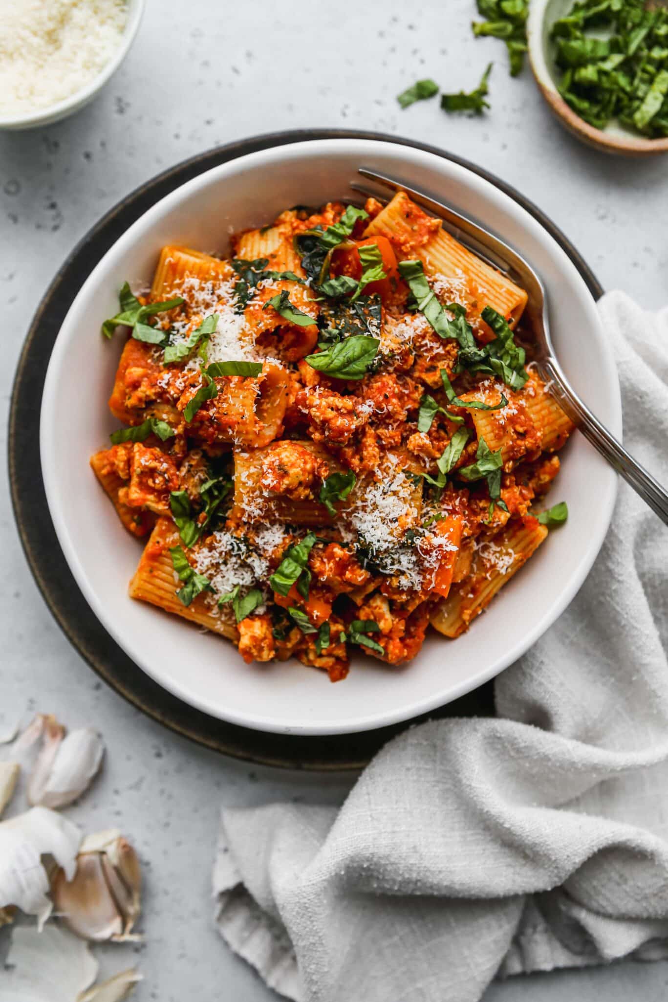 A bowl of pasta with meat sauce and parmesan cheese.