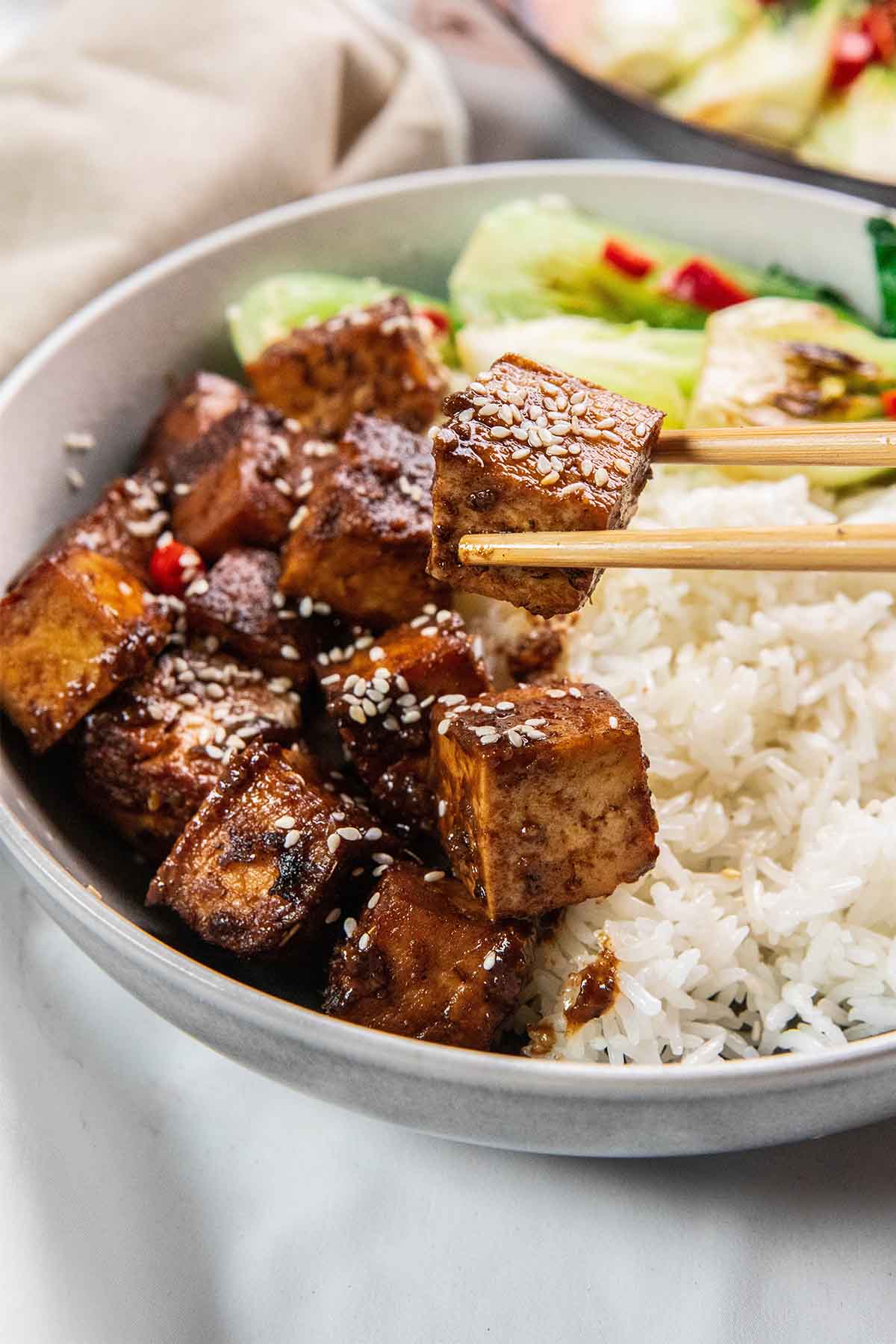 A bowl of food with chopsticks.