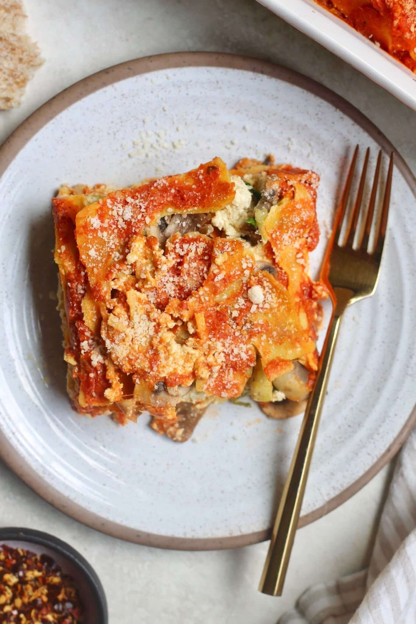 A slice of lasagna on a plate with a fork.