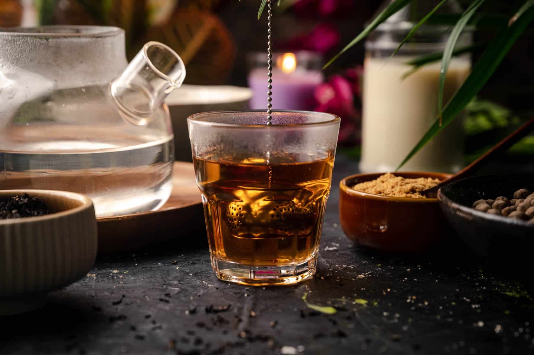 Loose leaf black tea steeping in a glass cup.