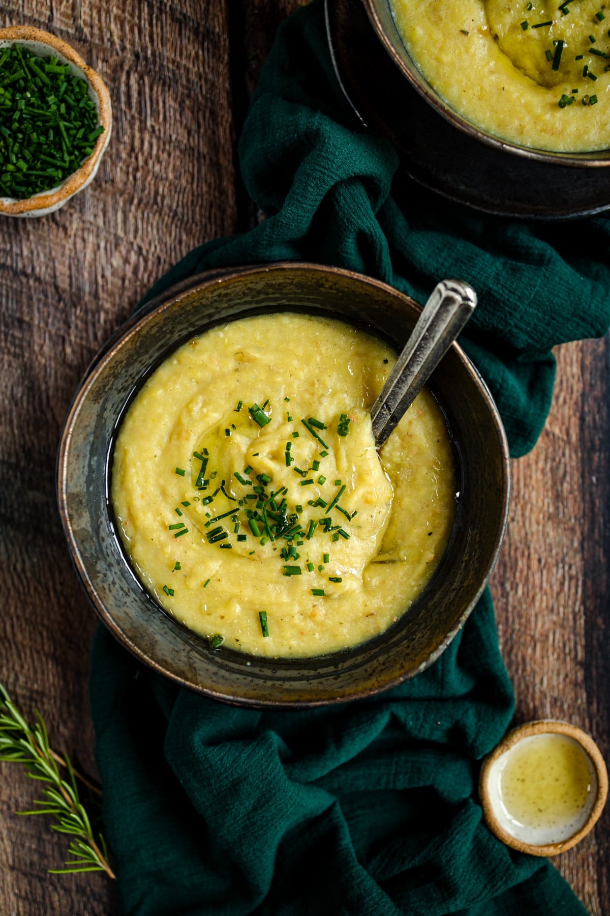 A bowl of soup with a spoon on a wooden table.