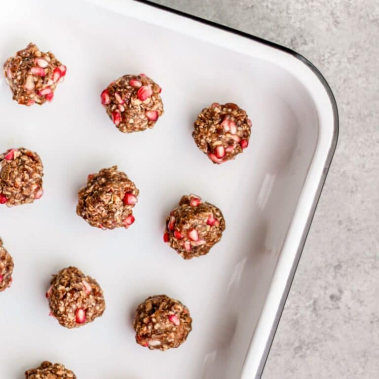 A white tray contains small round clusters of oatmeal balls.