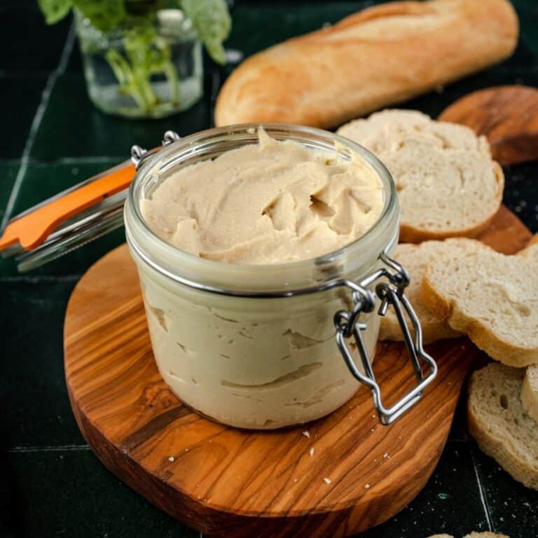 A jar of creamy cashew ricotta cheese in a glass jar.