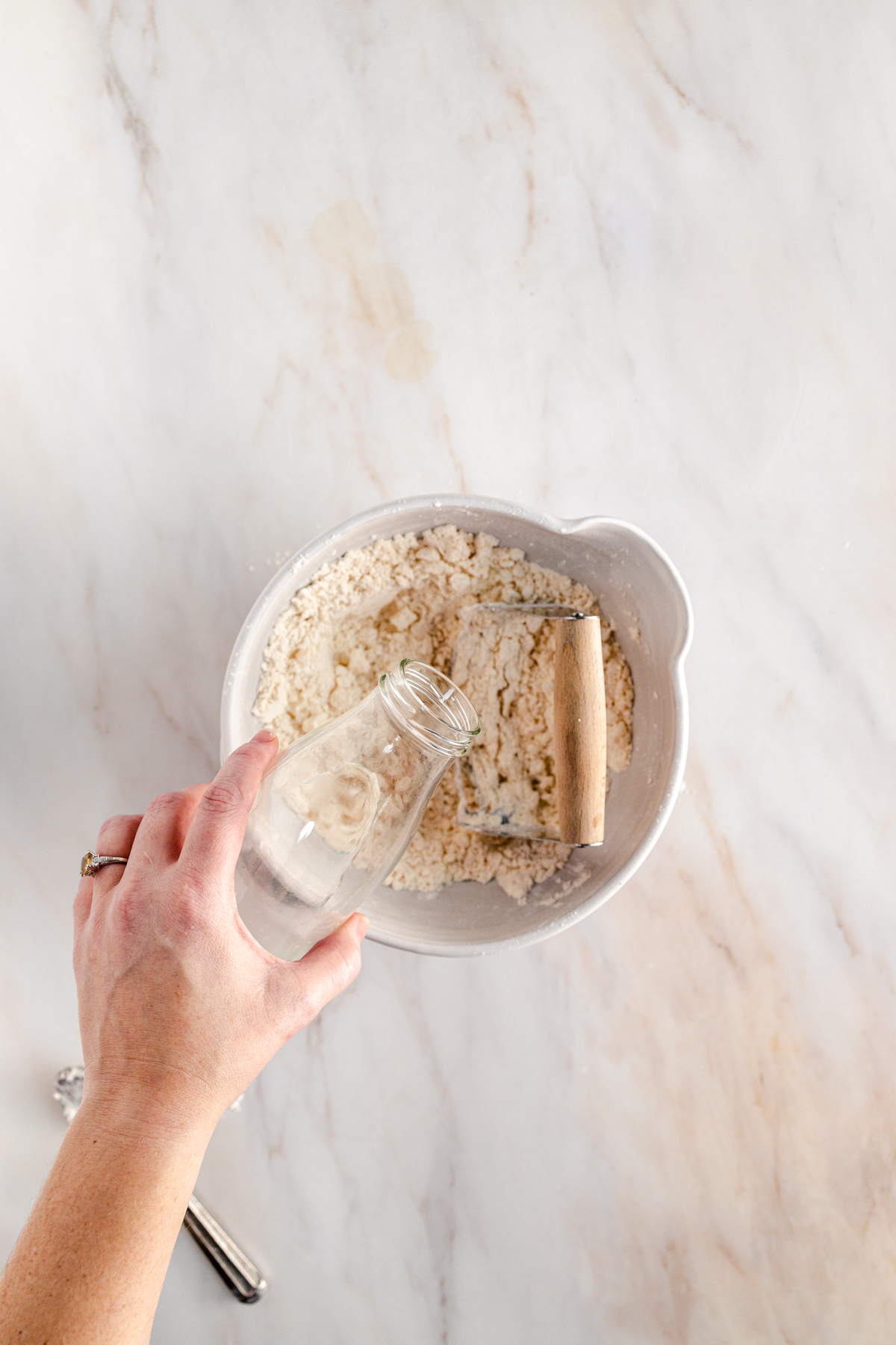 A person is mixing flour in a bowl.