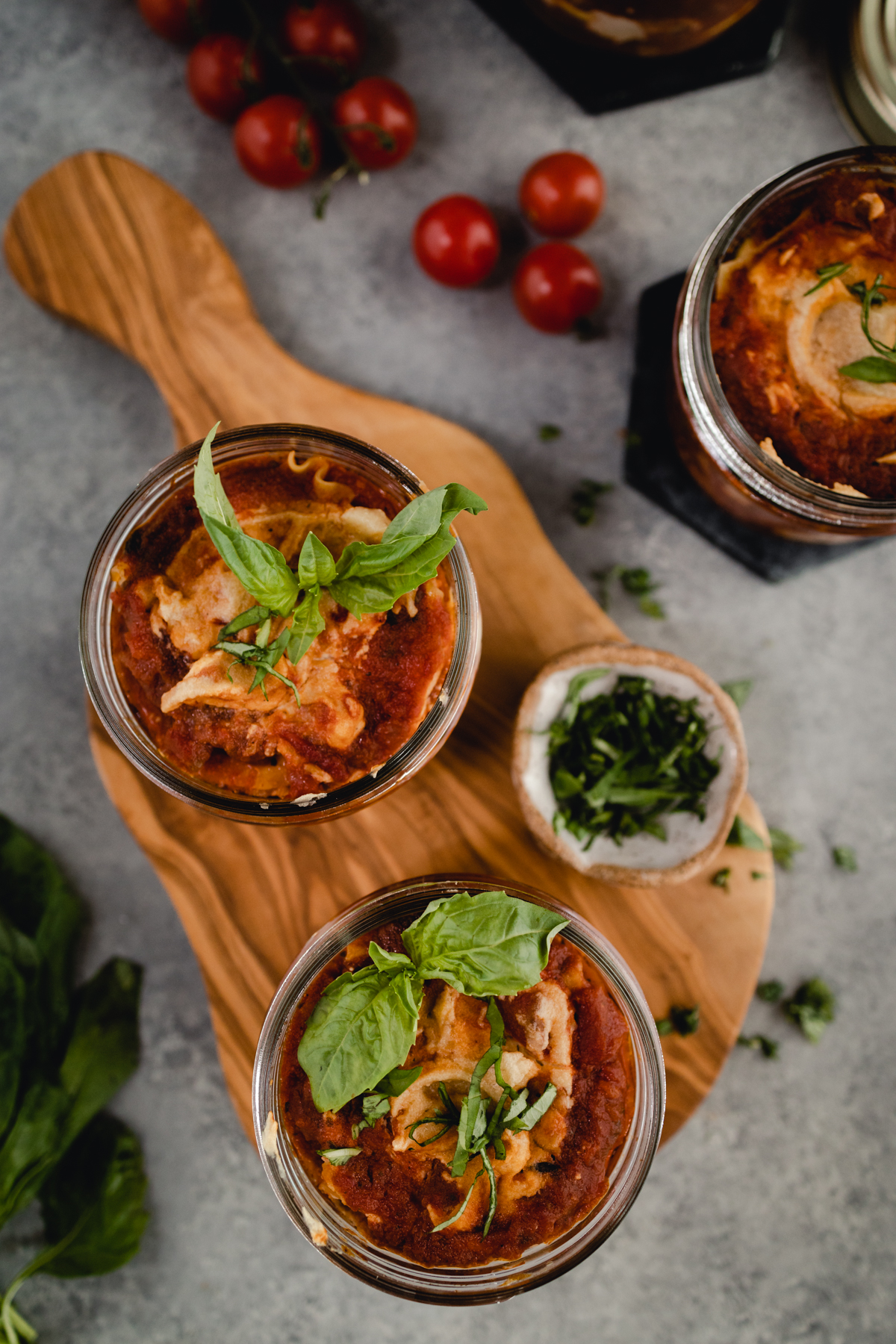 Homemade personal sized lasagnas on a wooden board.