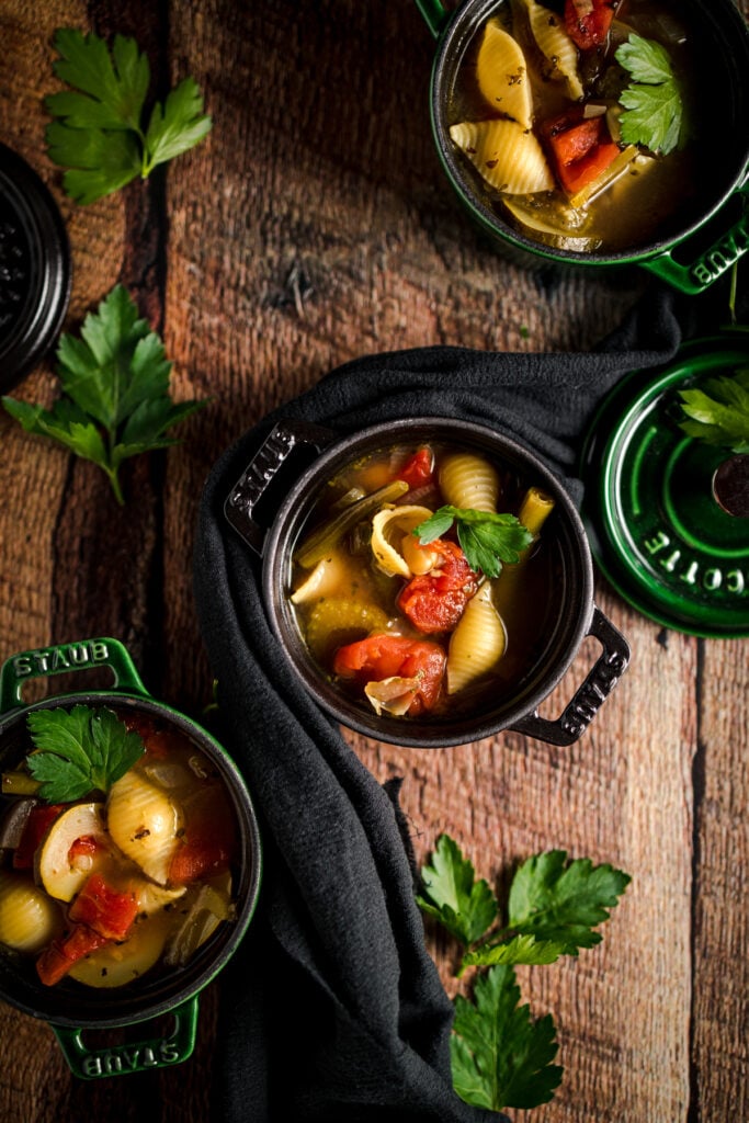 Three bowls of soup on a wooden table.