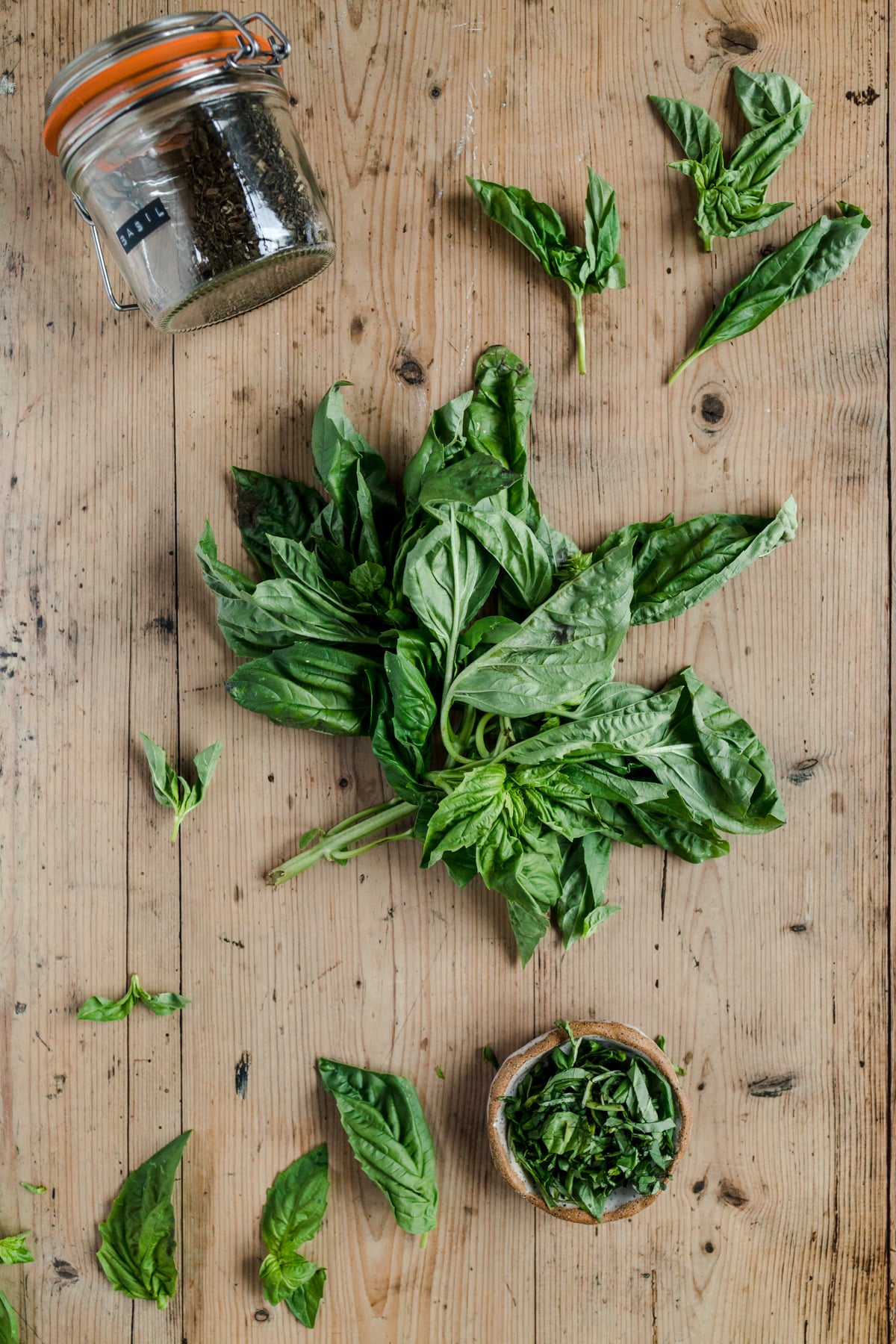 Fresh basil leaves on a wooden table.
