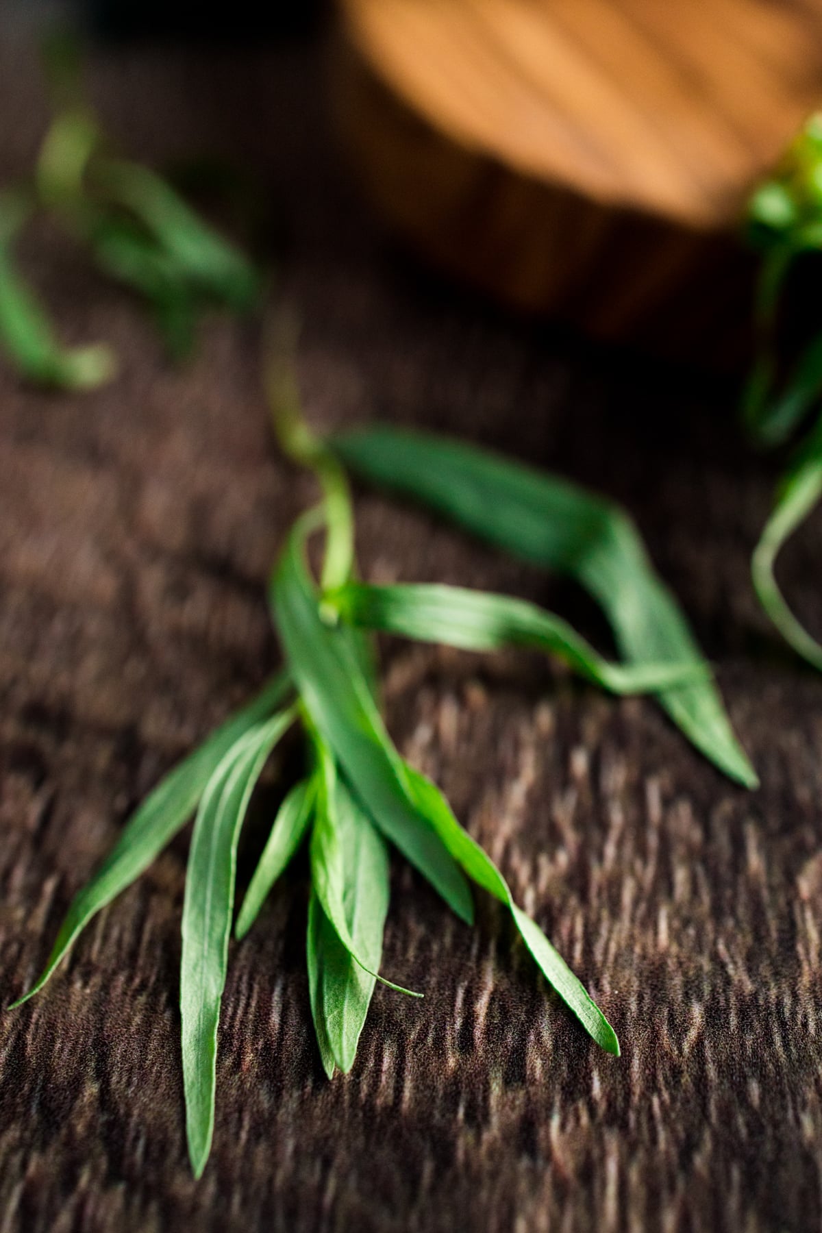 A bunch of green leaves on a wooden table.