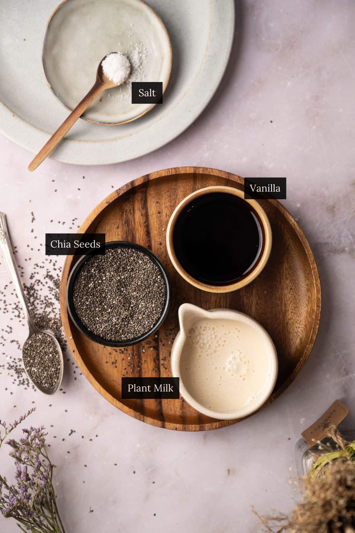 Ingredients for making vanilla chia pudding on a wooden plate.