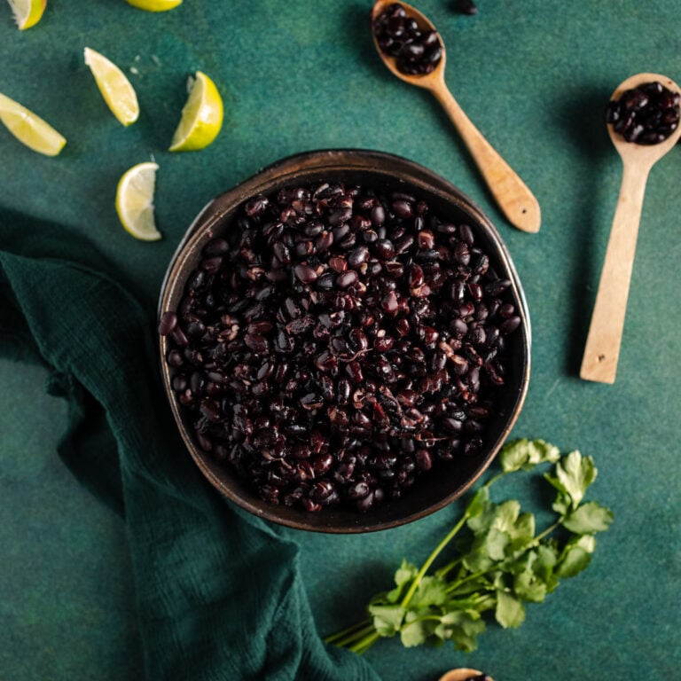Instant pot black beans in a bowl on a green table.