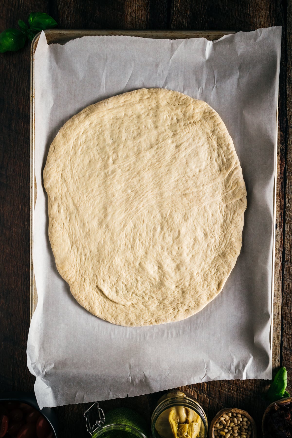 Homemade dough stretched out on a baking sheet.
