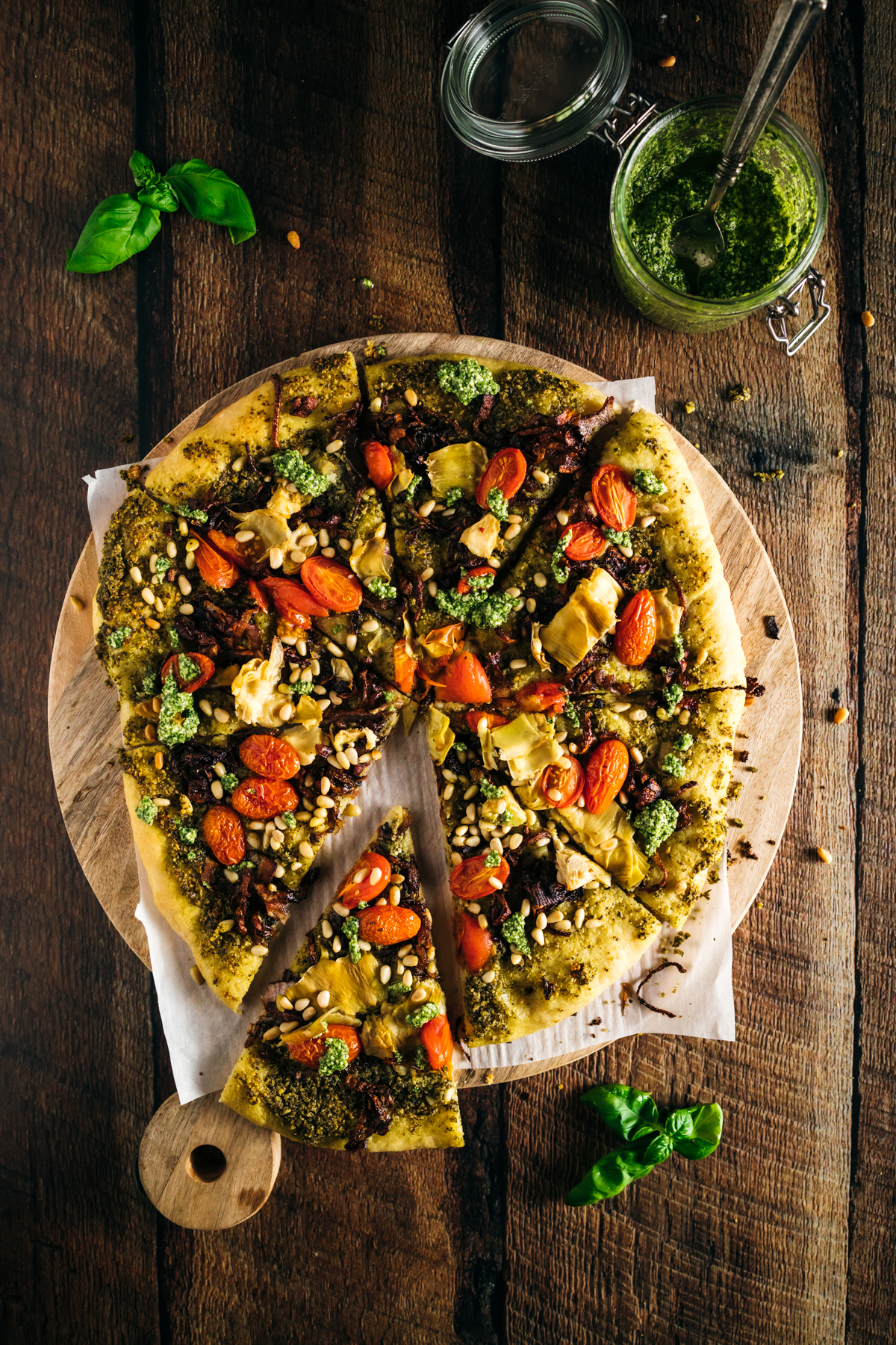 Sliced pizza is sitting on a wooden cutting board.