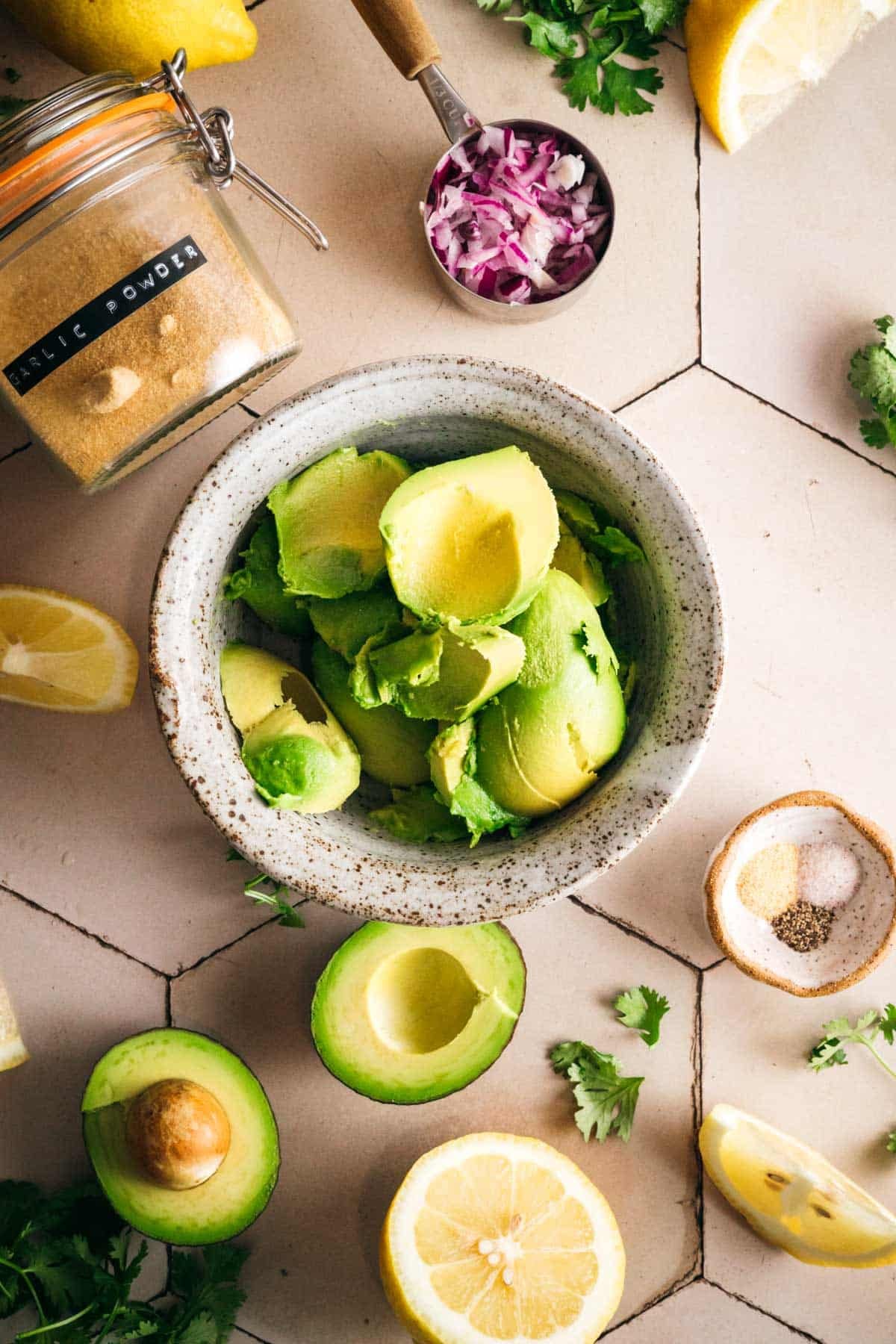 Scooping fresh avocado into a bowl.