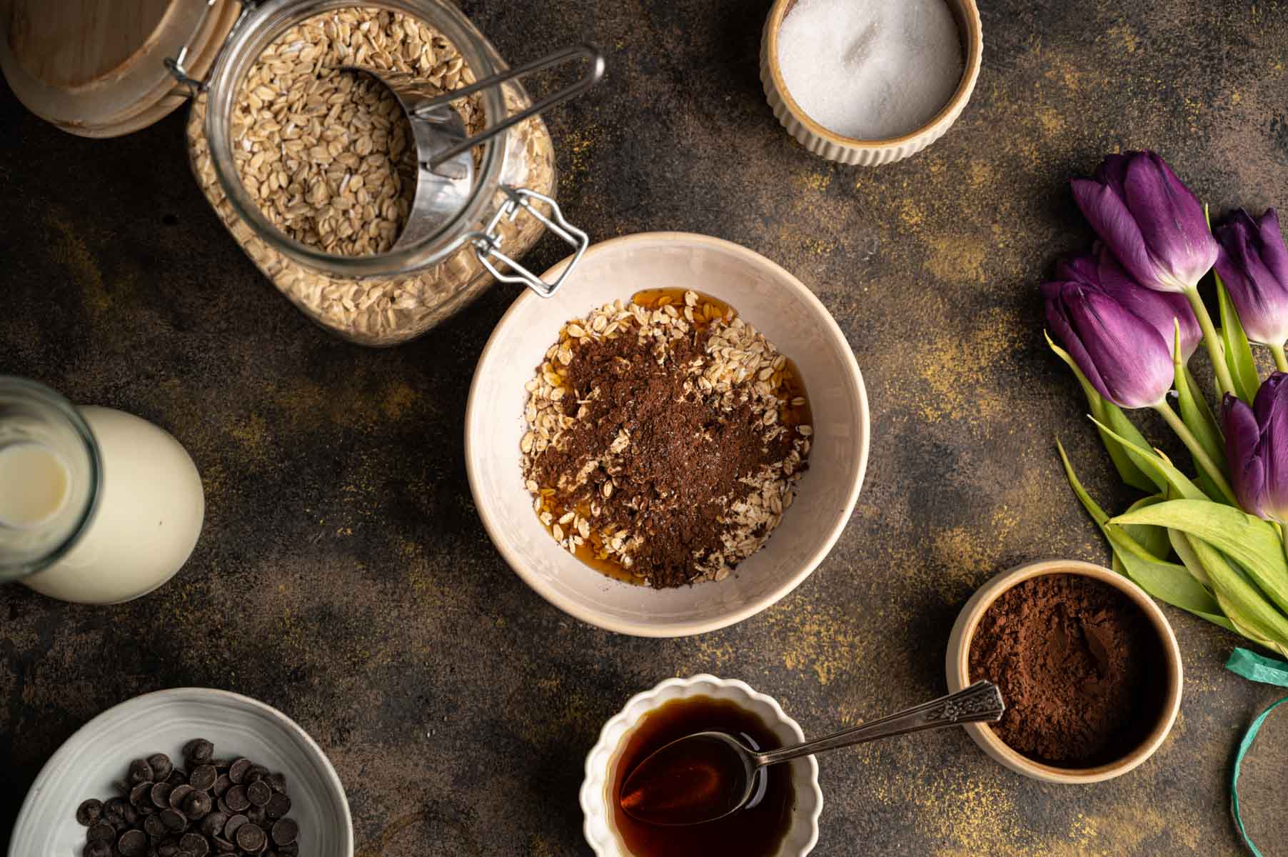 A table with ingredients for making chocolate oatmeal.