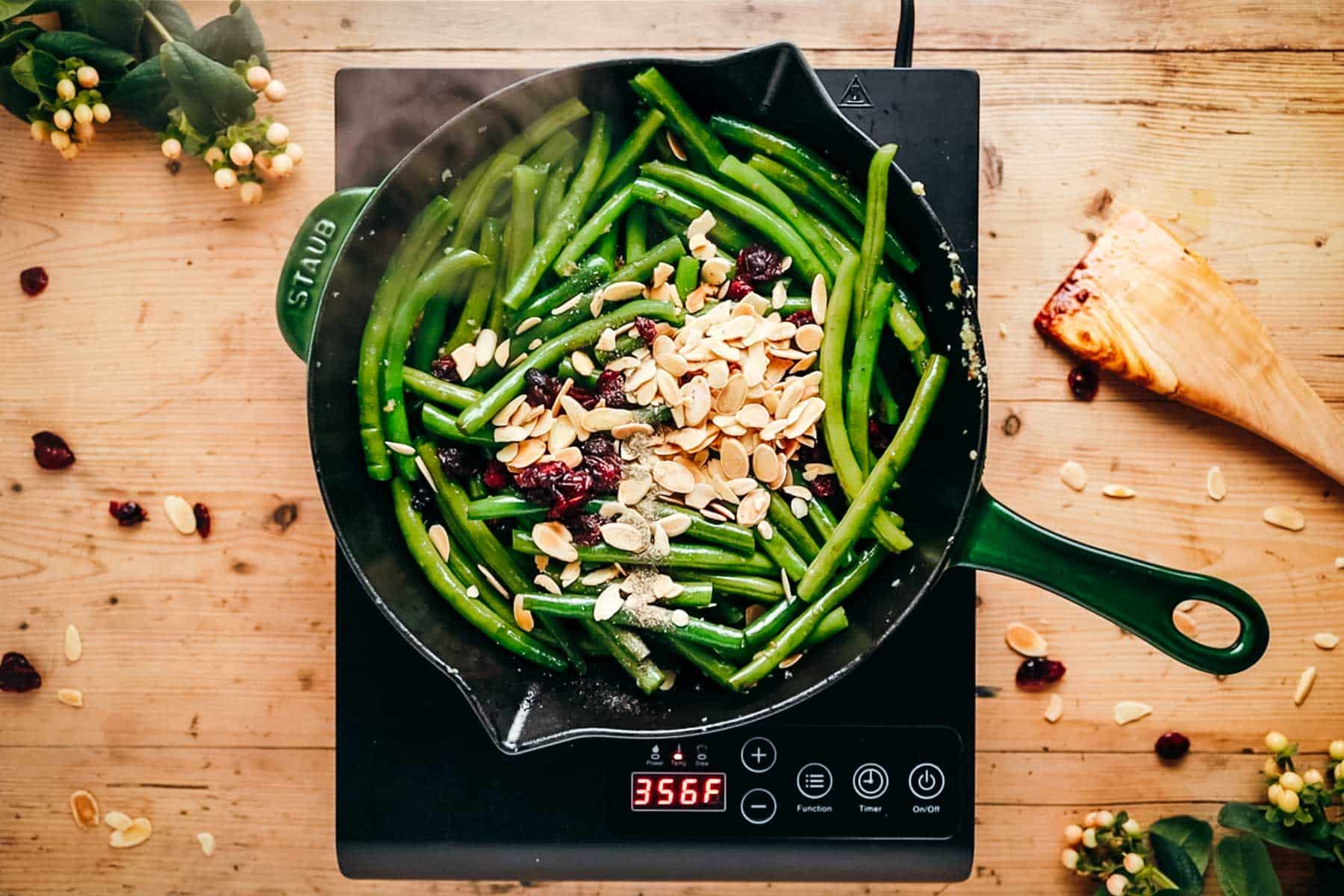 Green beans with almonds and cranberries in a pan.