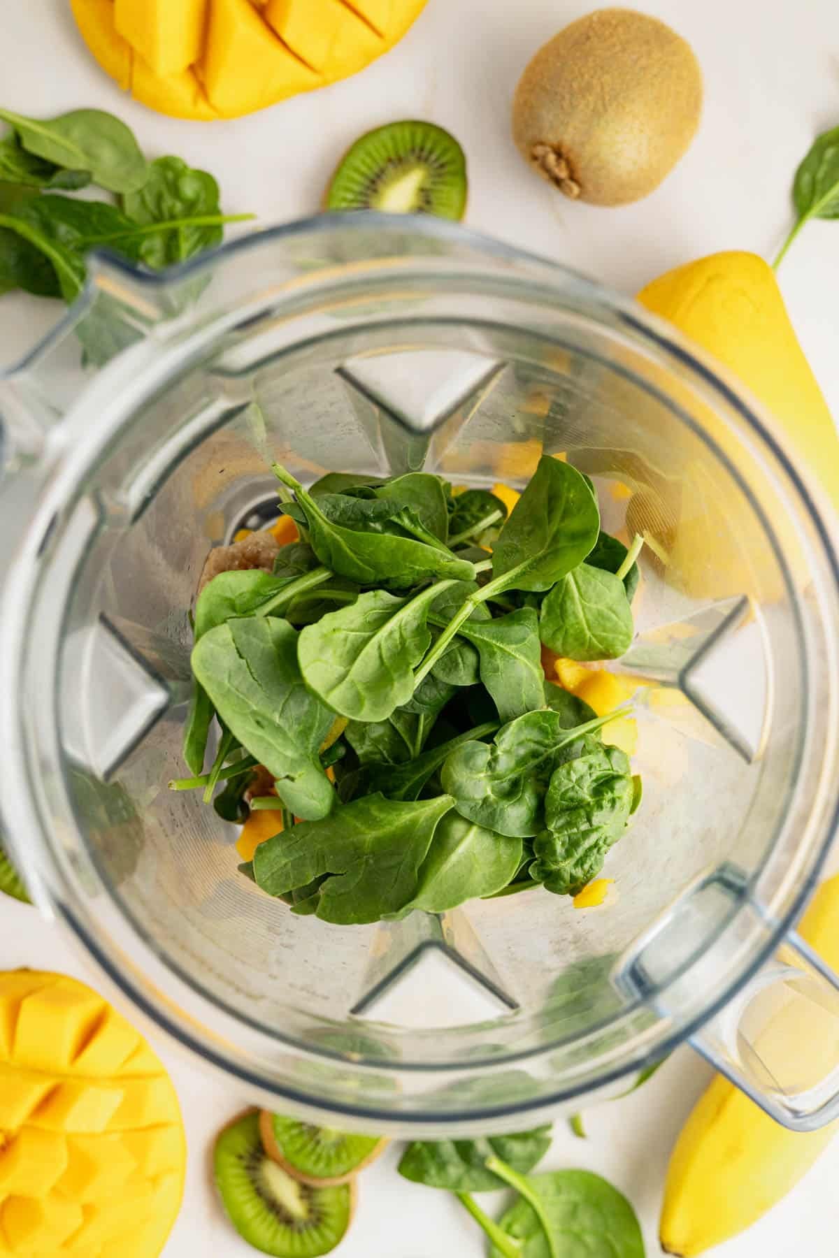 Spinach added to blender for kiwi smoothie.