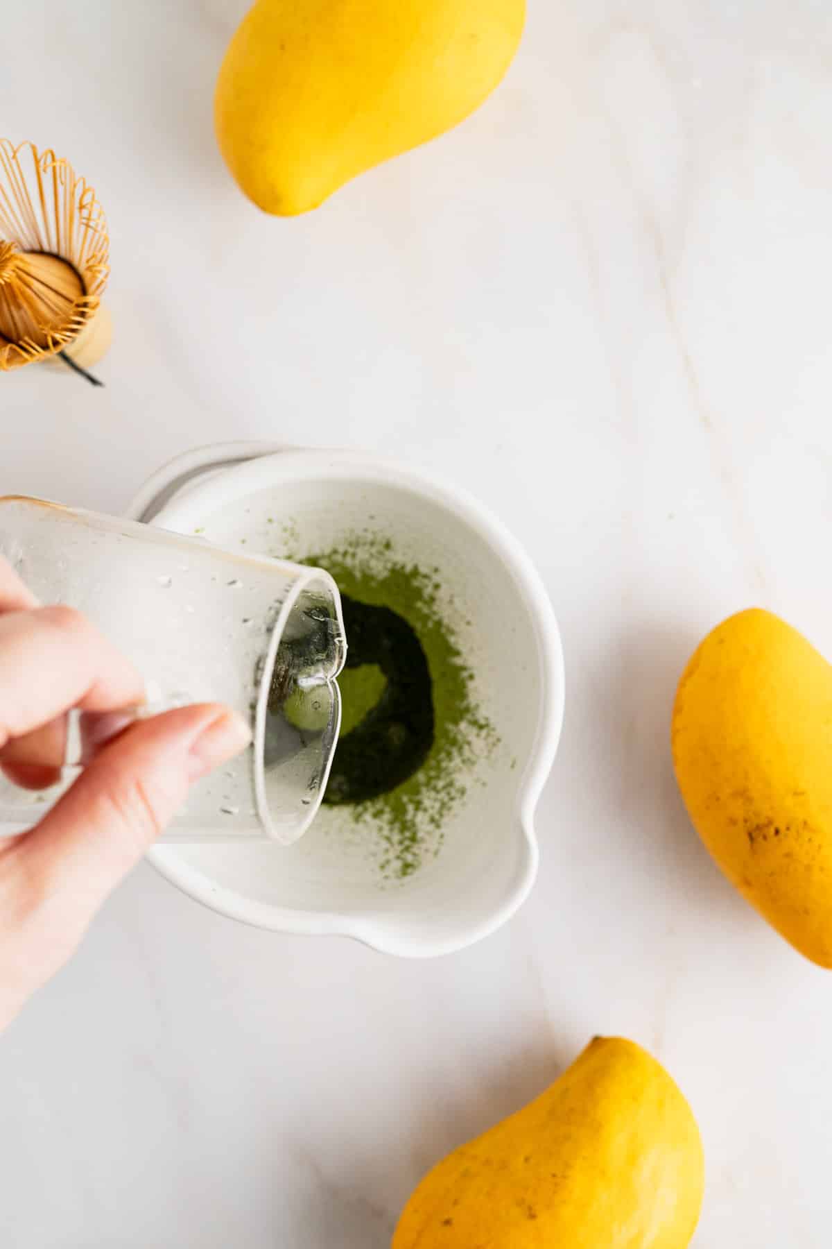 Pouring hot water over matcha green tea powder.