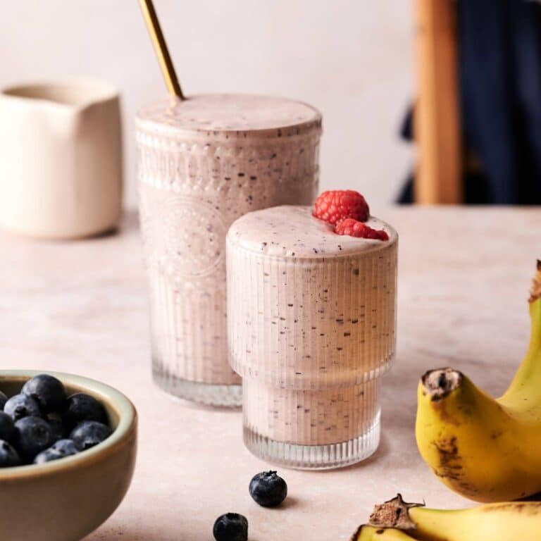 Two glasses of fresh blueberry raspberry banana smoothie.