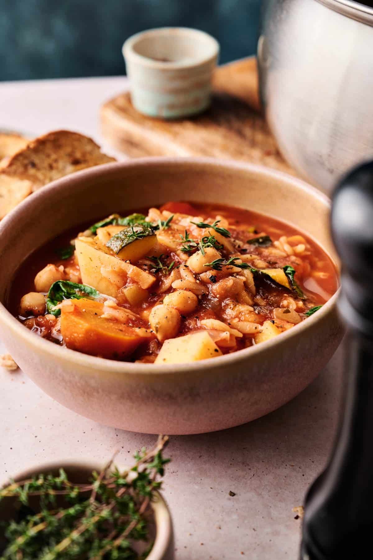Fresh bowl of cozy orzo soup on a marble table.