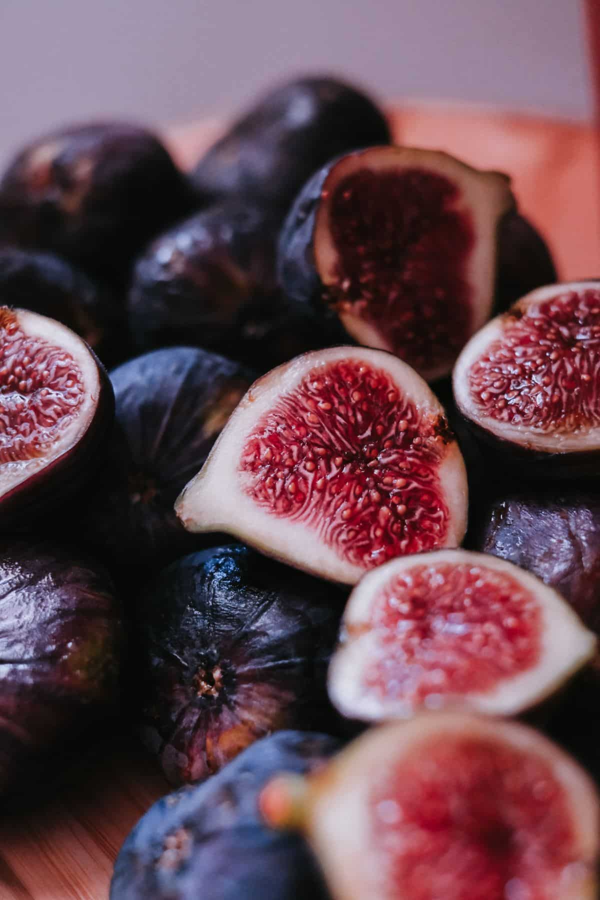 Pile of black figs with pink flesh.
